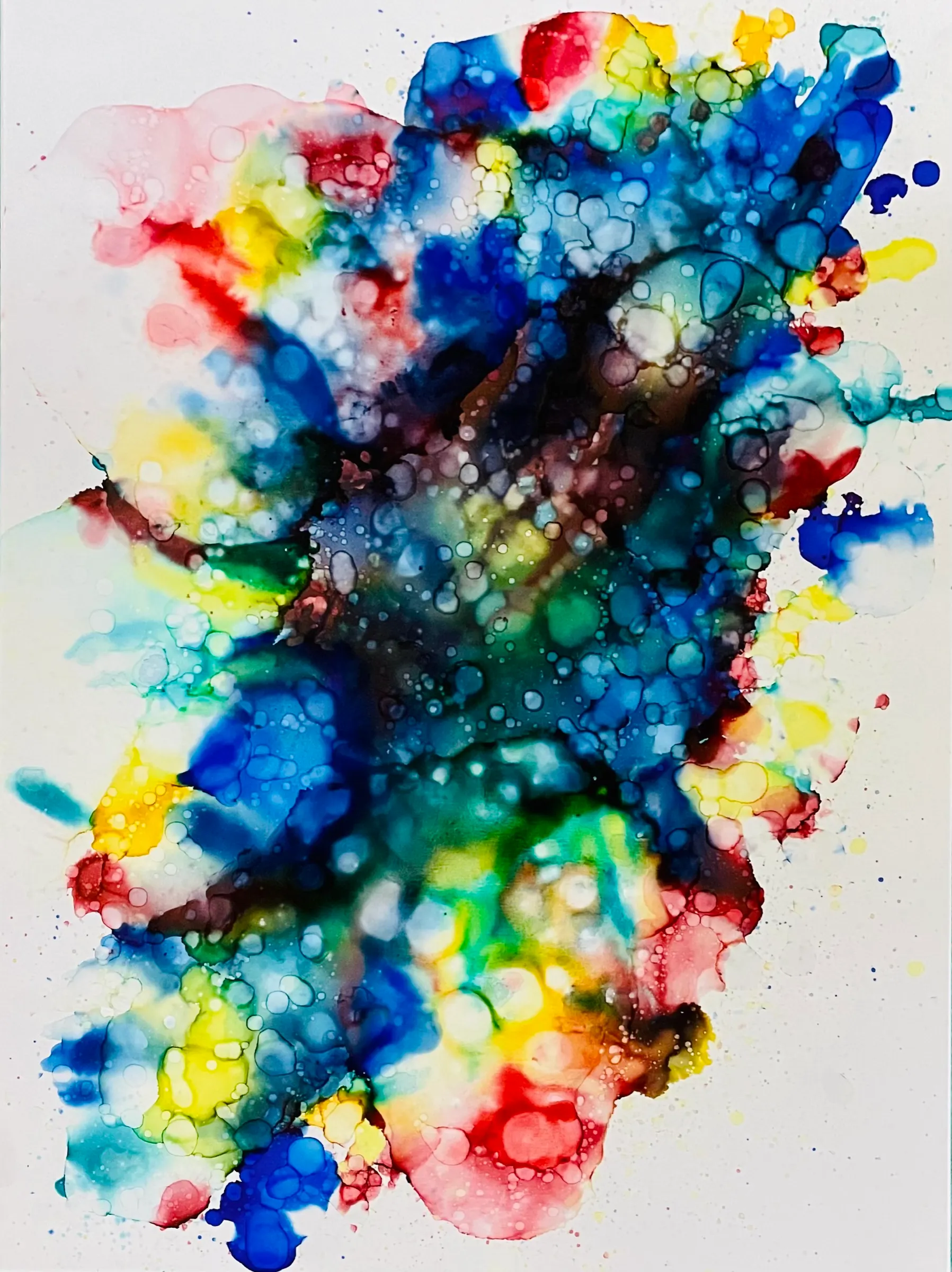 An abstract painting of pooled blue, yellow, red and green blots spreading outward from a dark center across a white ground.