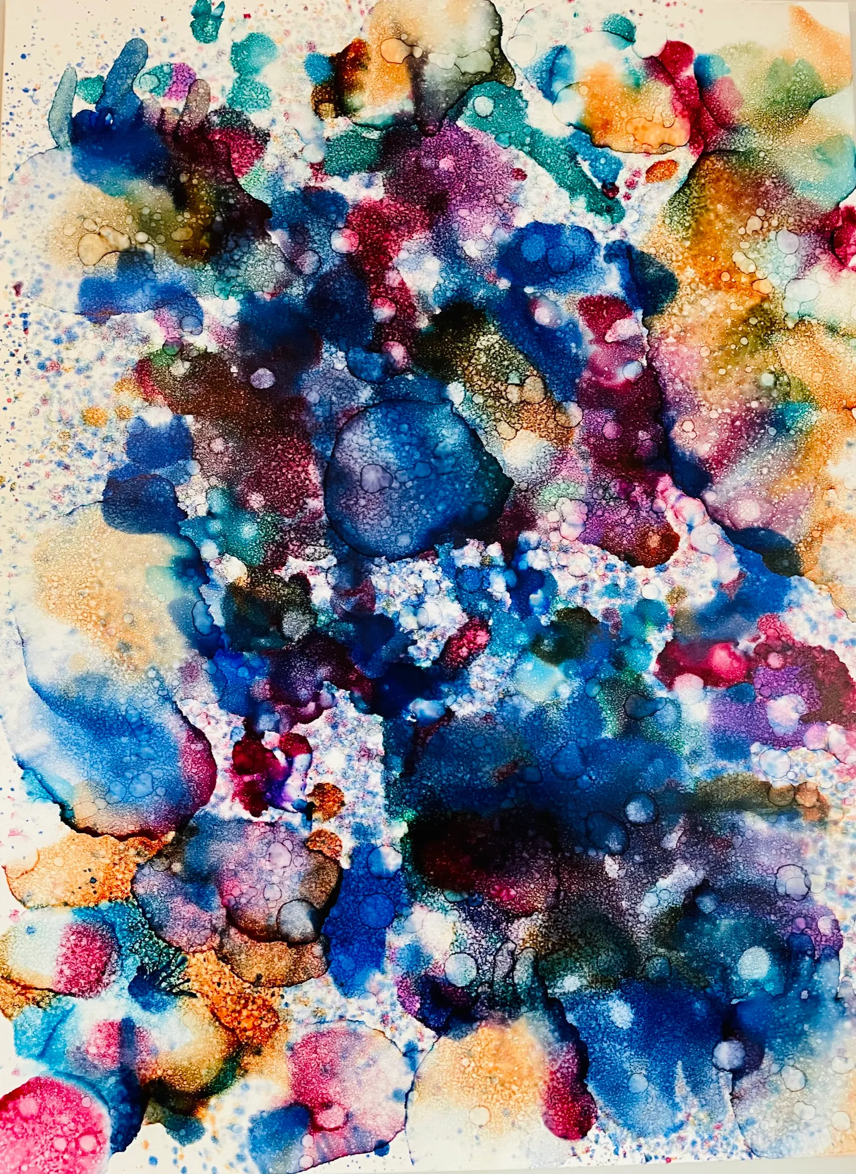 An abstract painting covered in overlapping blots of deep blue, magenta, copper and pale teal, speckled with metallic flecks on white.