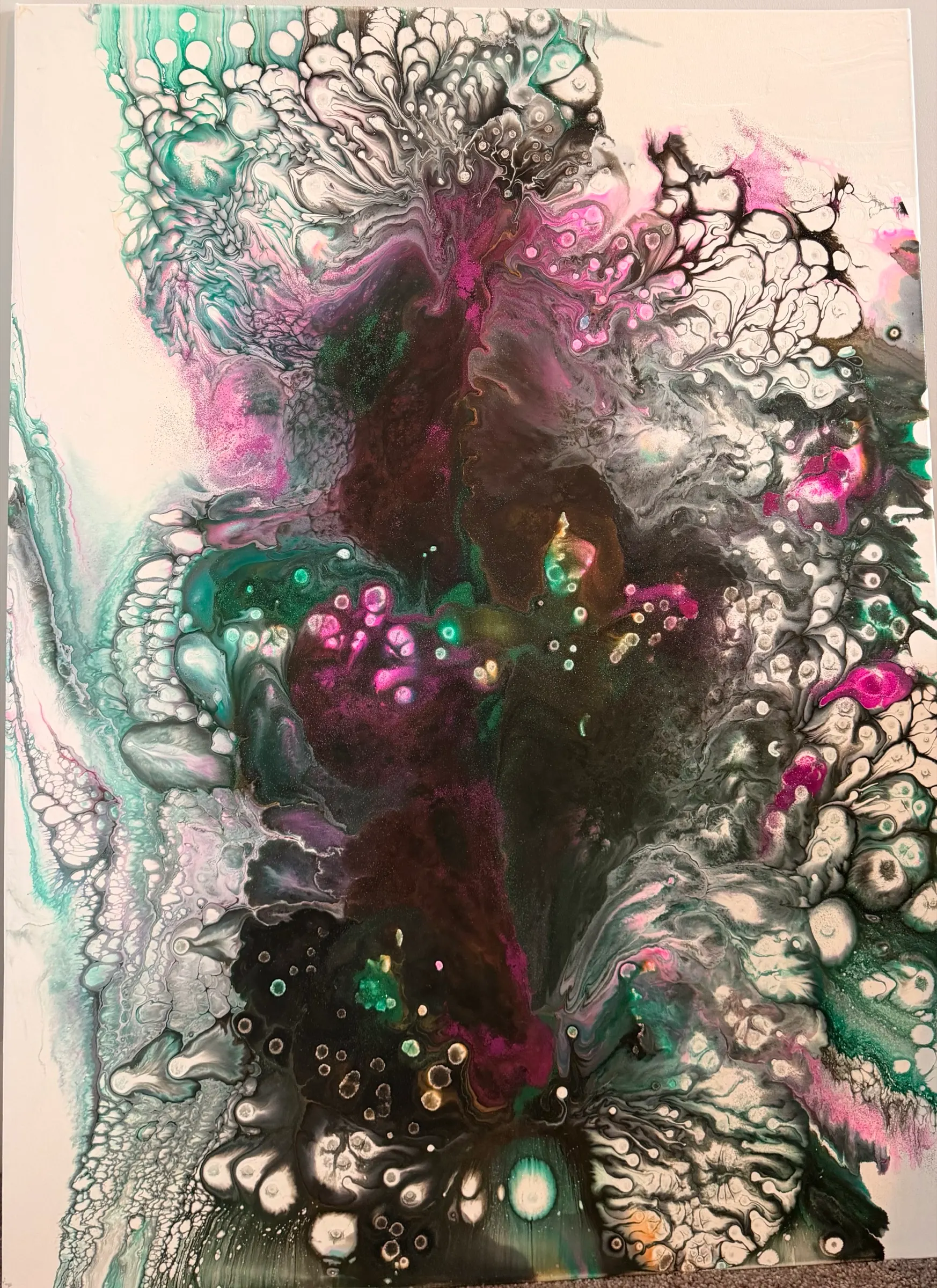 An abstract poured painting with a dark column of black with plum rising through the center, edged with cells of teal, magenta and white.