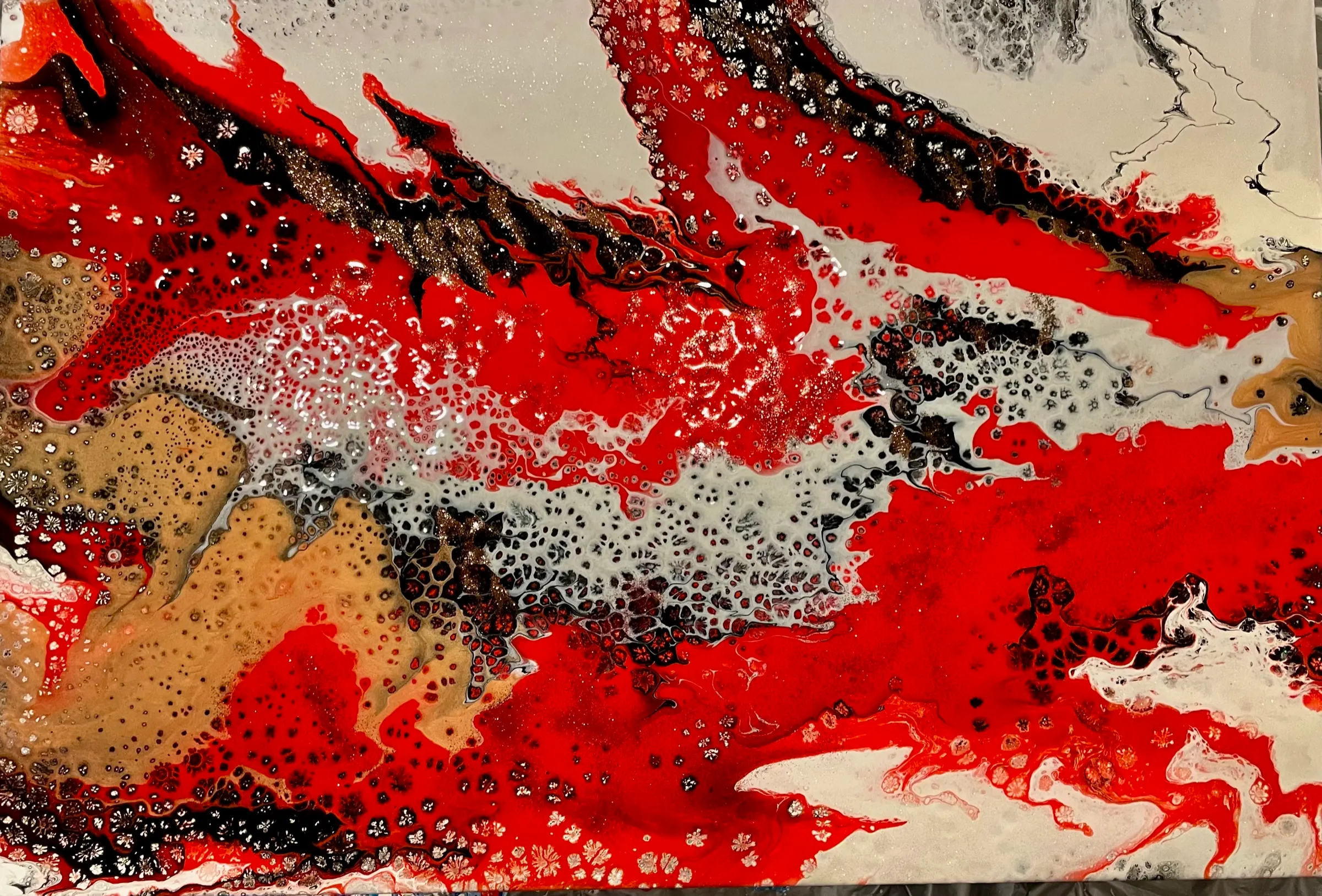 An abstract poured painting of bright red waves crossing a field of gray-white cells, with streaks of black, tan and copper.